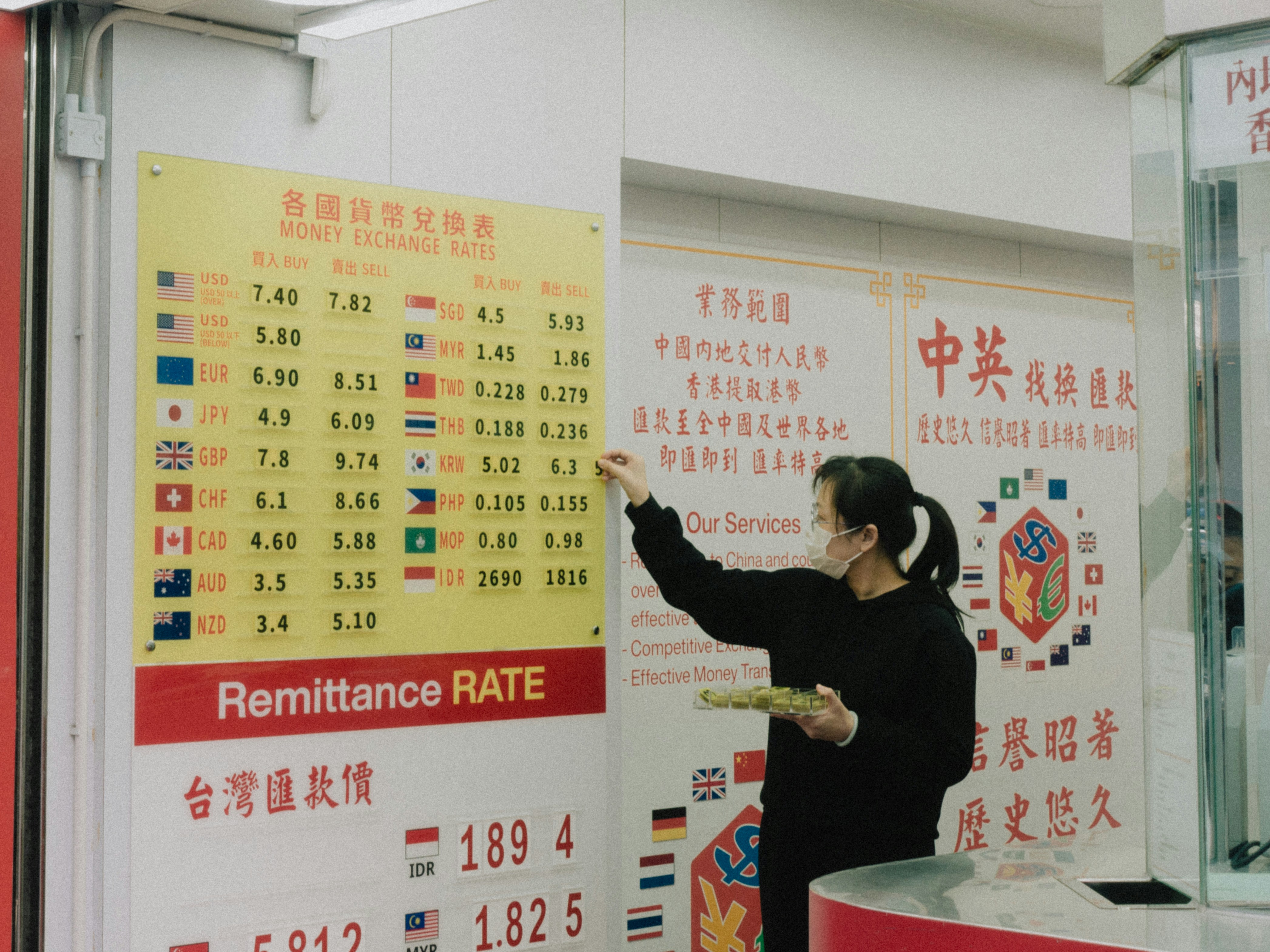 a woman standing in front of a sign pointing to a board